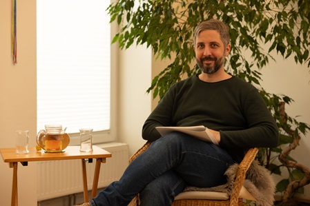 Psychologe Tobias Schabetsberger sitzend in der Praxis in 1200 Wien